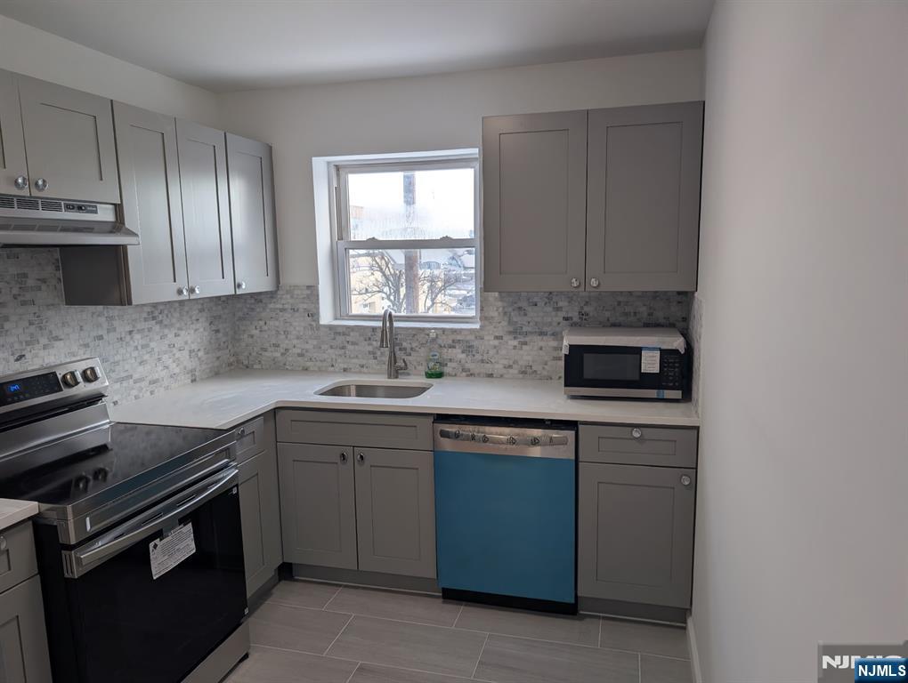 205 Bergen Turnpike, Unit 2E Ridgefield Park, NJ 07660 - Photo 2 of 9 a kitchen with stainless steel appliances granite countertop a sink stove and cabinets