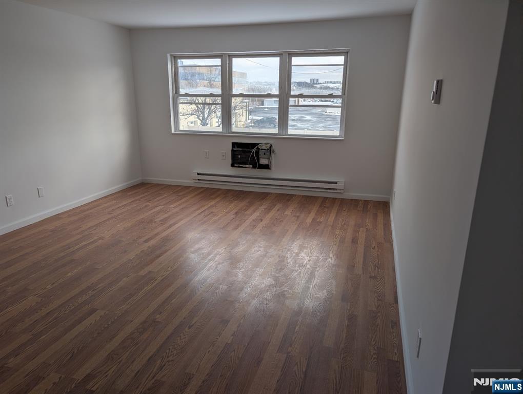 205 Bergen Turnpike, Unit 2E Ridgefield Park, NJ 07660 - Photo 9 of 9 an empty room with wooden floor and windows