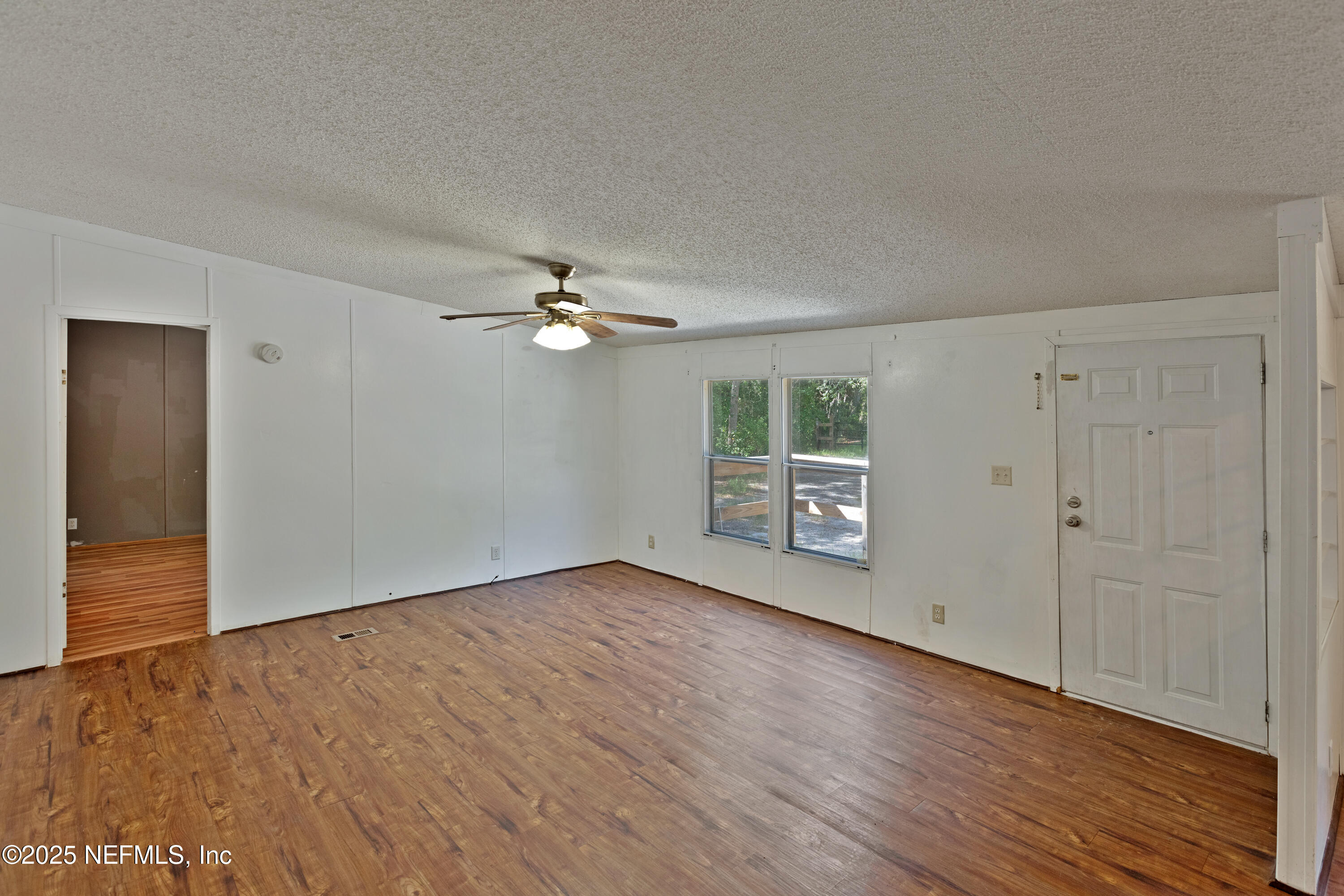 7463 Lilly Court Keystone Heights, FL 32656 - Photo 4 of 24 a view of an empty room with wooden floor and a window
