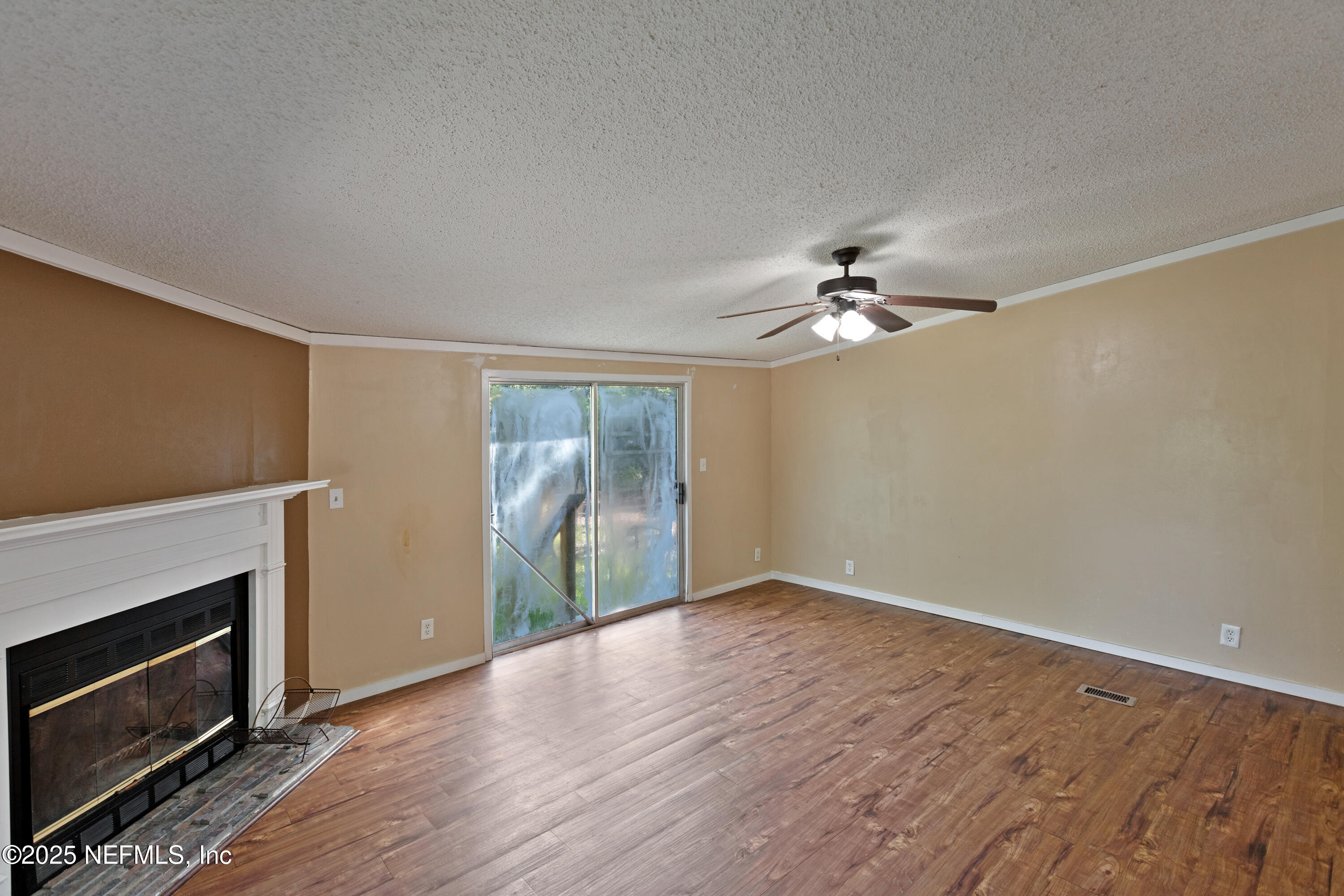 7463 Lilly Court Keystone Heights, FL 32656 - Photo 9 of 24 a view of a livingroom with a ceiling fan fireplace and wooden floor