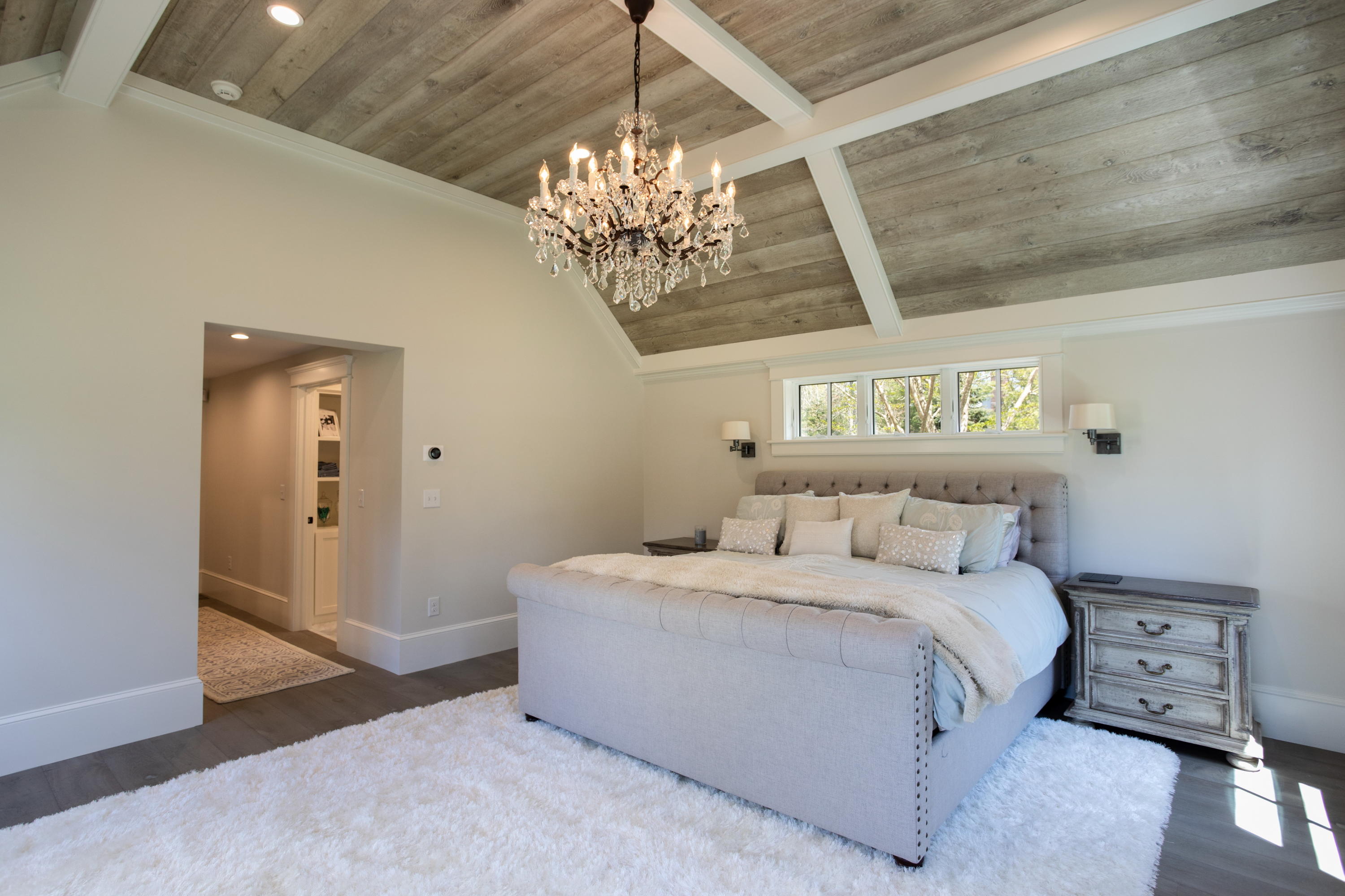 120 Smoke Valley Road Osterville, MA 02655 - Photo 20 of 64 a bedroom with a bed and a chandelier