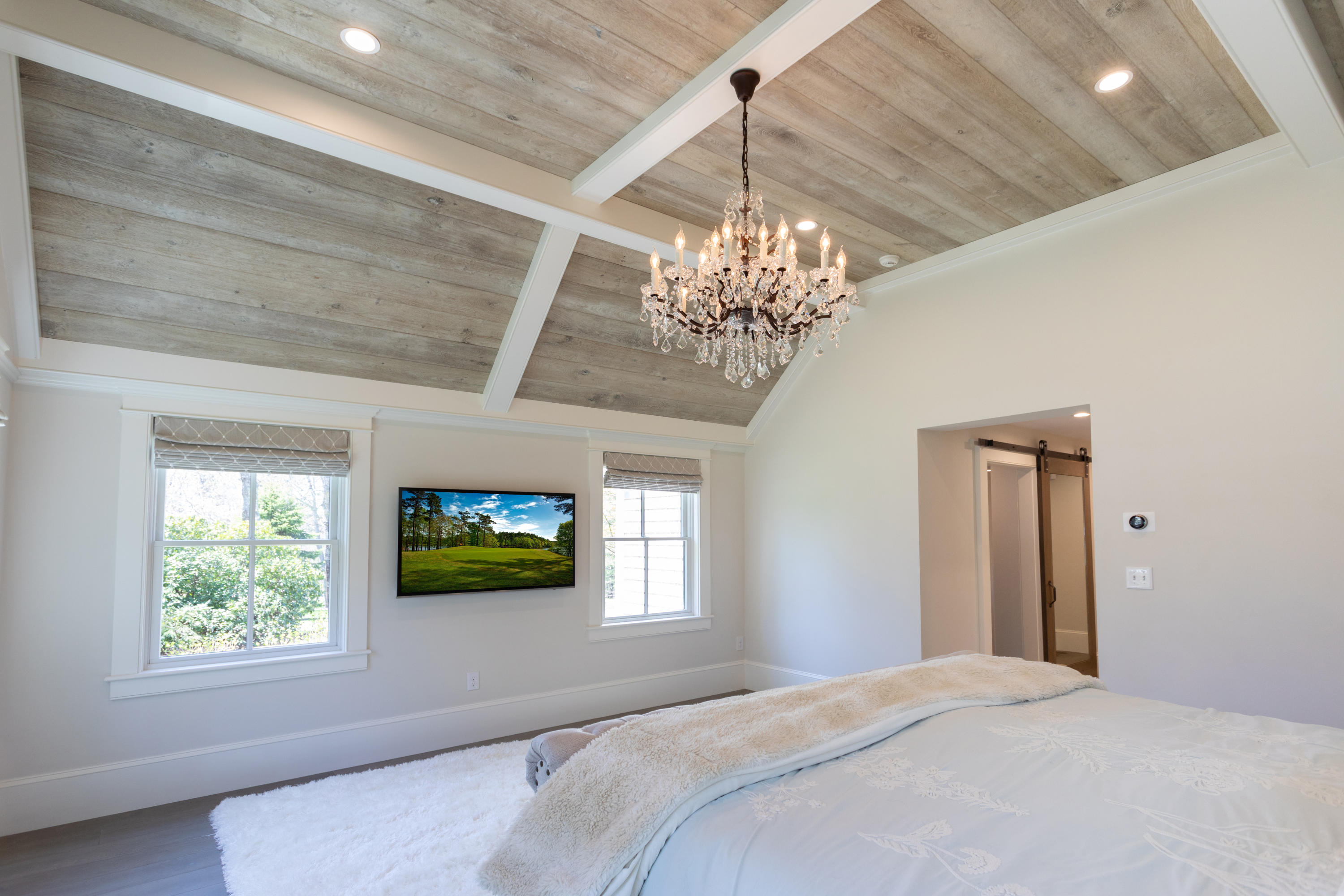 120 Smoke Valley Road Osterville, MA 02655 - Photo 21 of 64 a bedroom with a bed and a chandelier