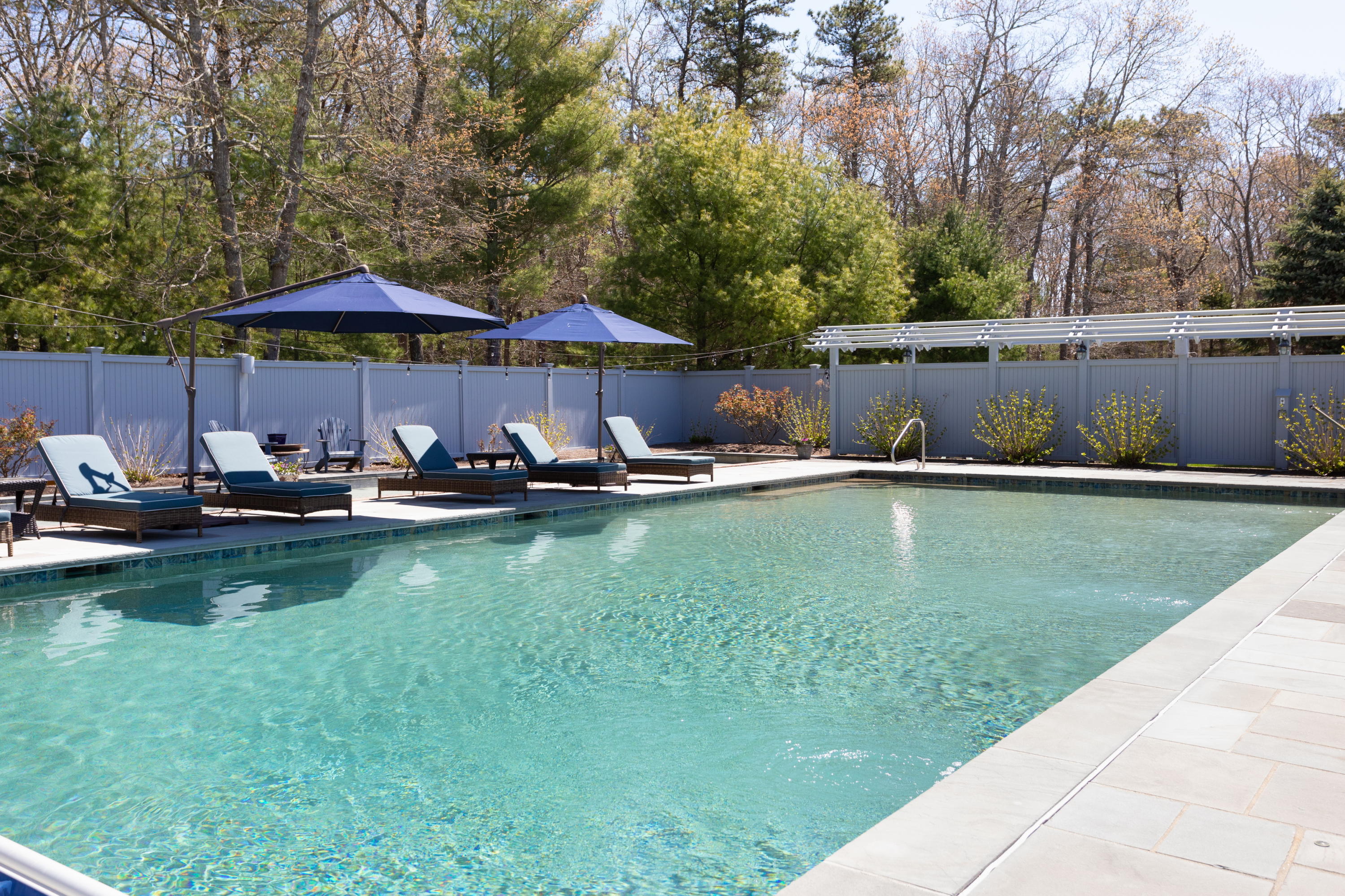 120 Smoke Valley Road Osterville, MA 02655 - Photo 45 of 64 a view of a swimming pool with lawn chairs under an umbrella
