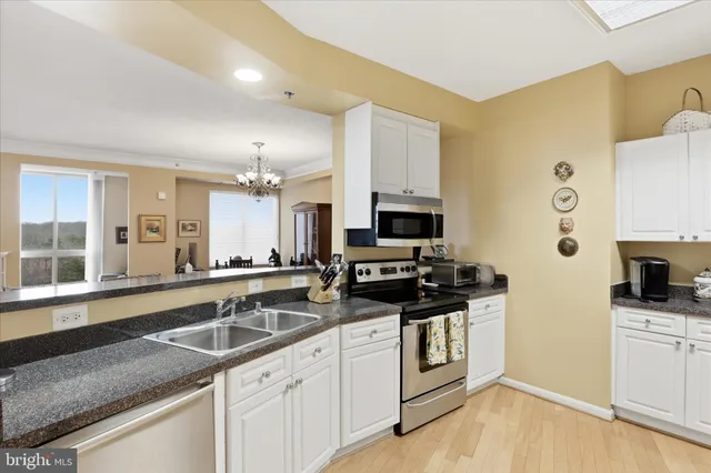 a kitchen with stainless steel appliances a stove a sink a microwave and wooden cabinets
