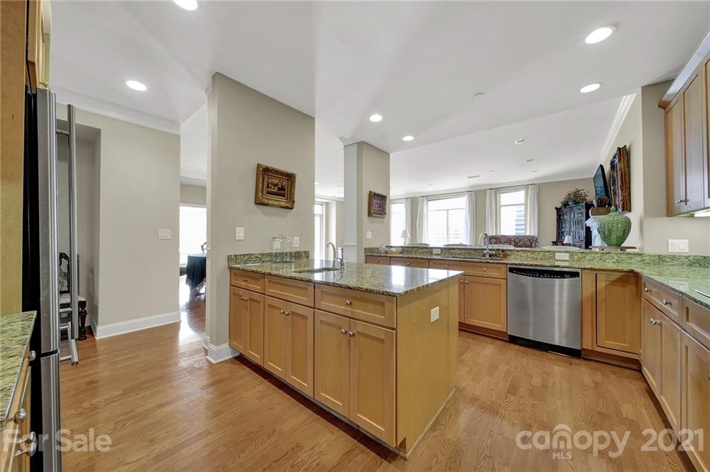 435 South Tryon Street, Unit 706 Charlotte, NC 28202 - Photo 13 of 40 a large kitchen with granite countertop a large counter top space and stainless steel appliances