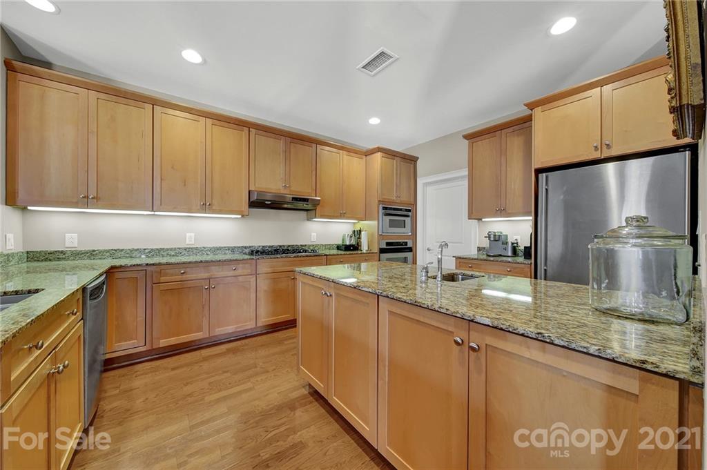 435 South Tryon Street, Unit 706 Charlotte, NC 28202 - Photo 15 of 40 a kitchen with stainless steel appliances granite countertop a sink refrigerator and cabinets