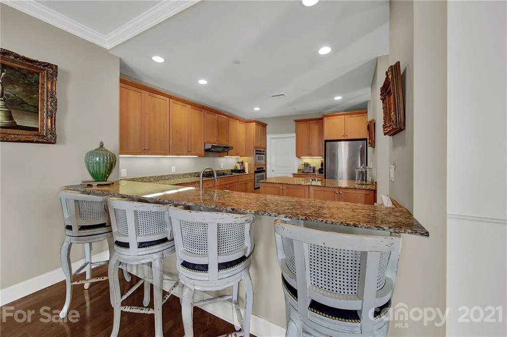 435 South Tryon Street, Unit 706 Charlotte, NC 28202 - Photo 23 of 40 a kitchen with granite countertop sink table and chairs