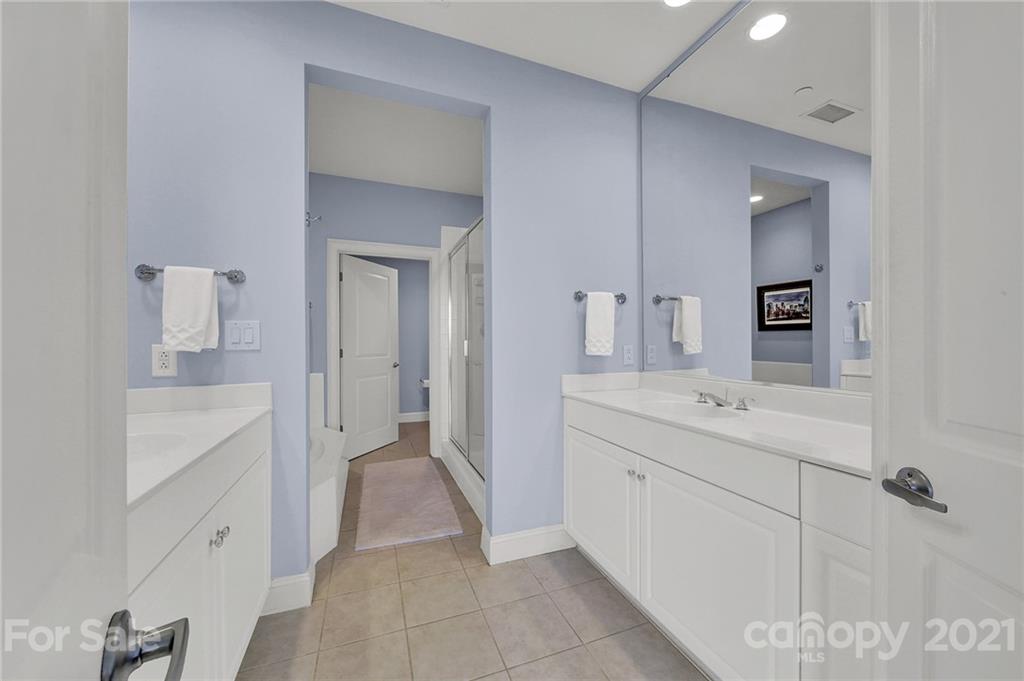 435 South Tryon Street, Unit 706 Charlotte, NC 28202 - Photo 30 of 40 a spacious bathroom with a shower sink and mirror