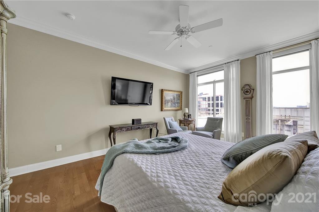 435 South Tryon Street, Unit 706 Charlotte, NC 28202 - Photo 32 of 40 a bedroom with a bed and glass window