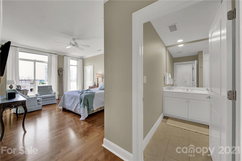 435 South Tryon Street, Unit 706 Charlotte, NC 28202 - Photo 34 of 40 a spacious bedroom with a bed and wooden floor