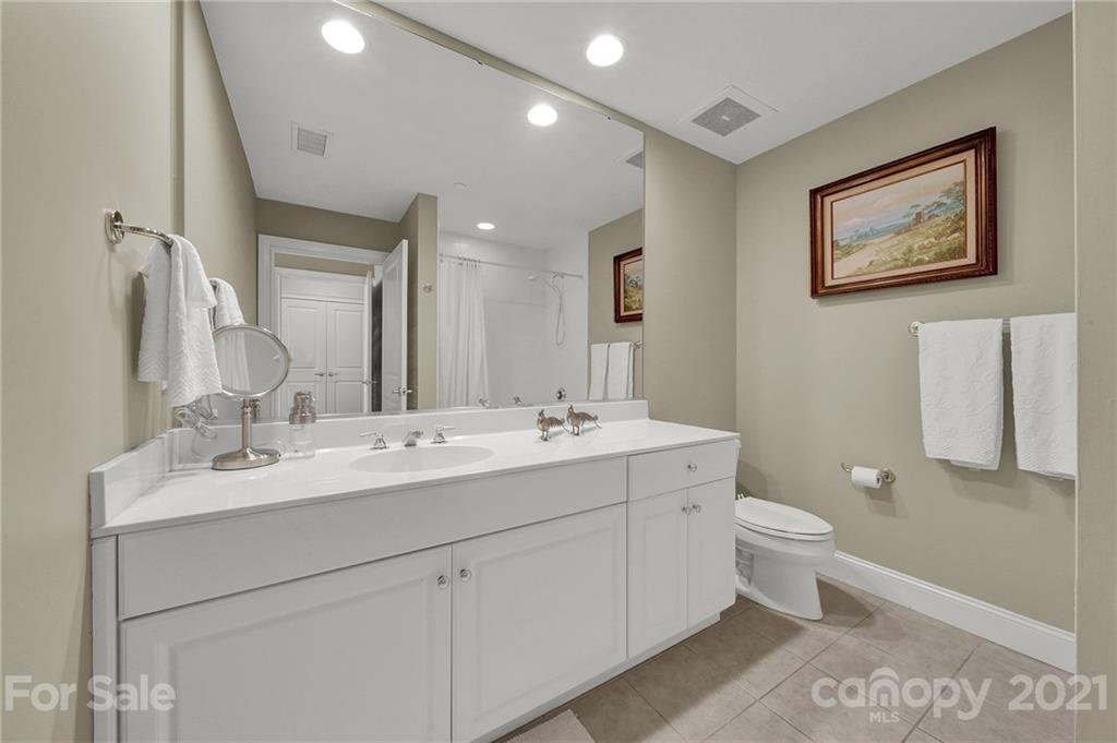 435 South Tryon Street, Unit 706 Charlotte, NC 28202 - Photo 36 of 40 a bathroom with a toilet sink double vanity and mirror