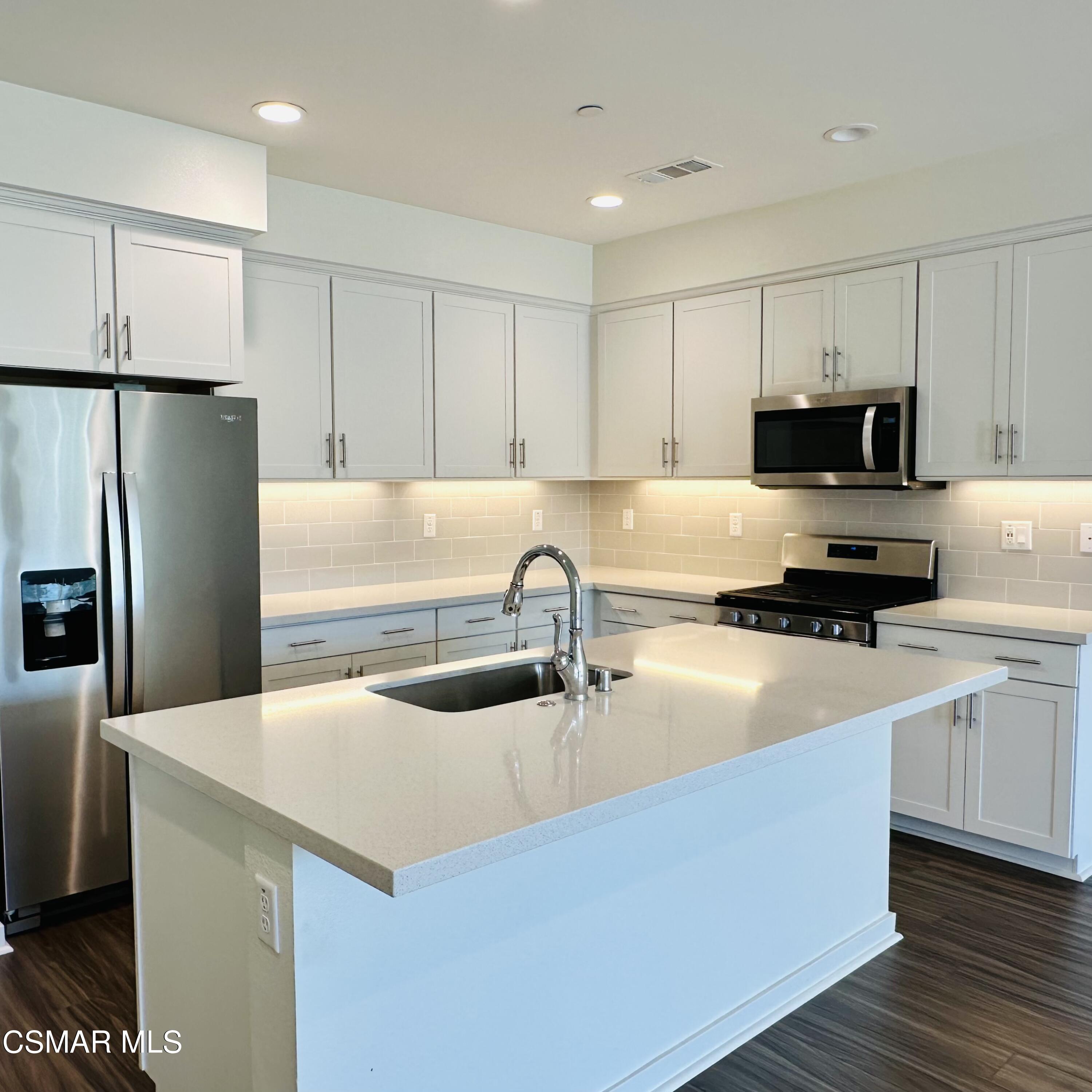 300 Farmhouse Drive, Unit 4 Simi Valley, CA 93065 - Photo 7 of 22 a kitchen with stainless steel appliances a refrigerator sink and white cabinets