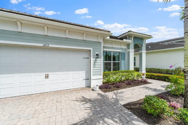 a front view of a house with a yard and potted plants