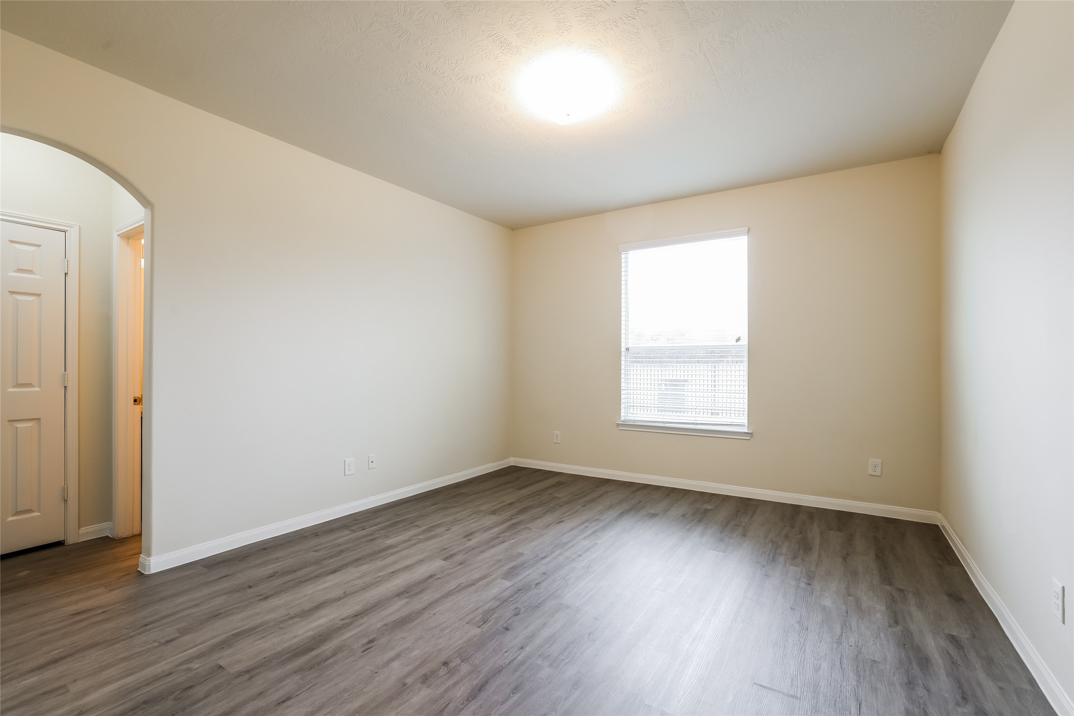 12431 Roy Mix Bohn Lane Houston, TX 77044 - Photo 11 of 13 an empty room with wooden floor and windows