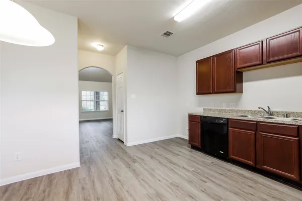 a kitchen with wooden floors and wooden cabinets