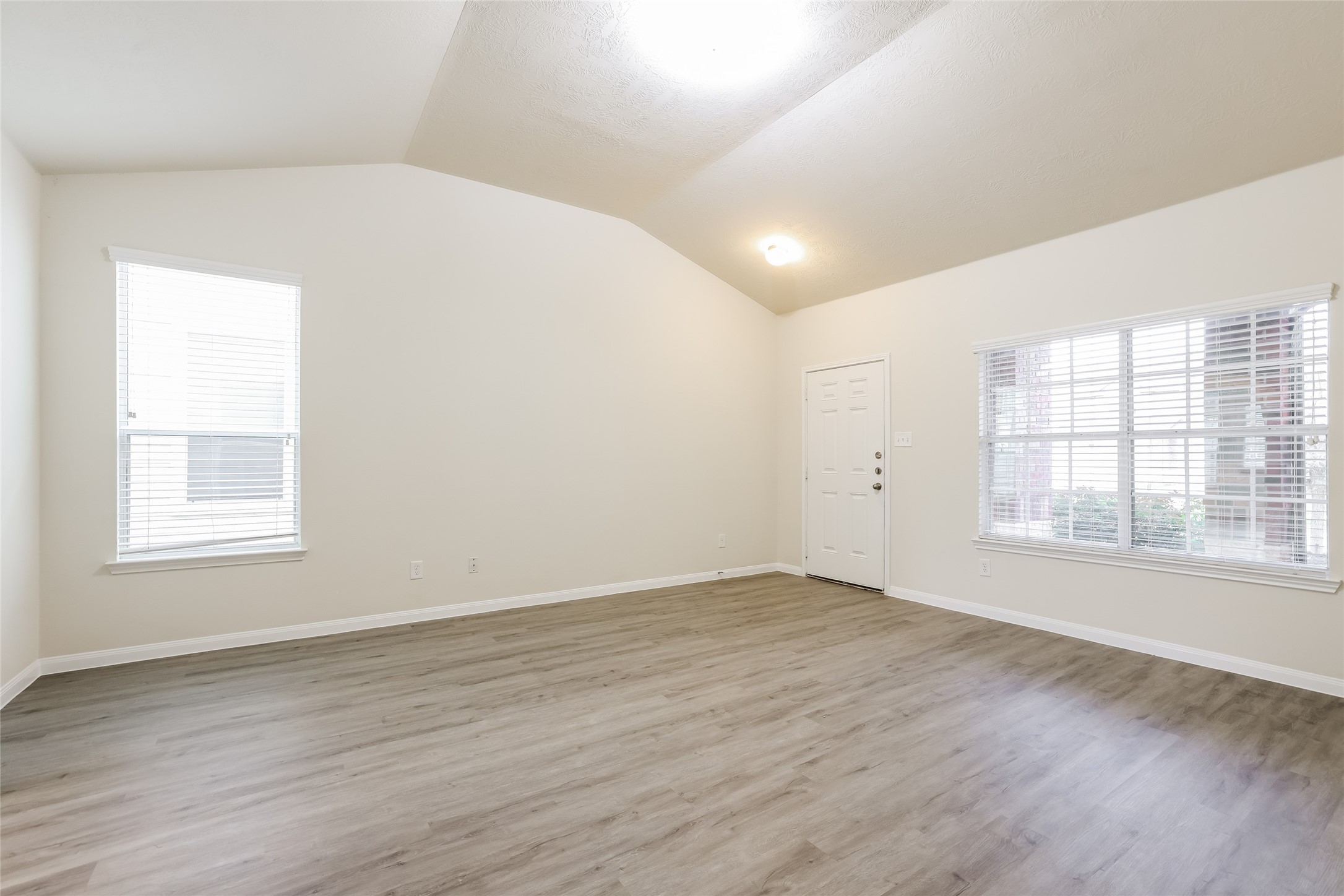12431 Roy Mix Bohn Lane Houston, TX 77044 - Photo 5 of 13 an empty room with wooden floor and windows