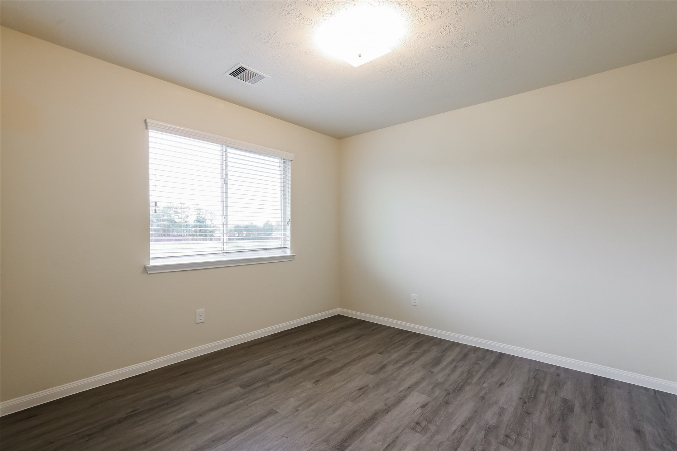 12431 Roy Mix Bohn Lane Houston, TX 77044 - Photo 7 of 13 an empty room with wooden floor and windows