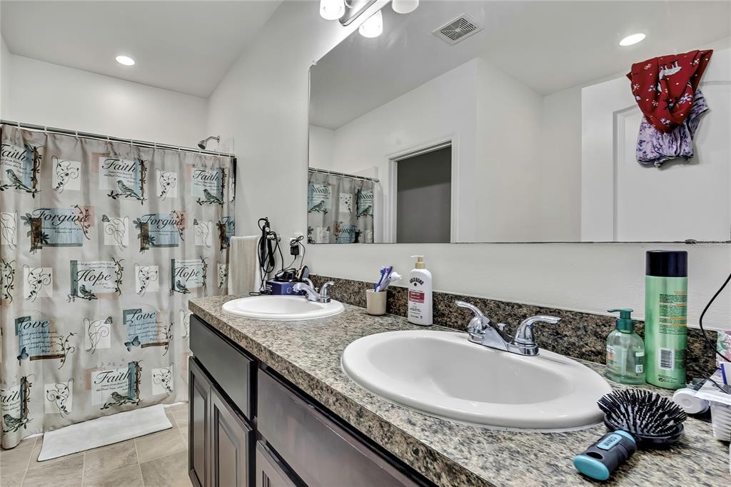 16197 Medrick Road Weeki Wachee, FL 34614 - Photo 11 of 22 a bathroom with a granite countertop double vanity sink a mirror and shower