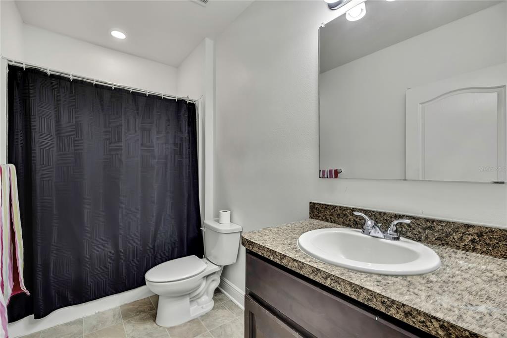 16197 Medrick Road Weeki Wachee, FL 34614 - Photo 18 of 22 a bathroom with a granite countertop sink toilet and a mirror