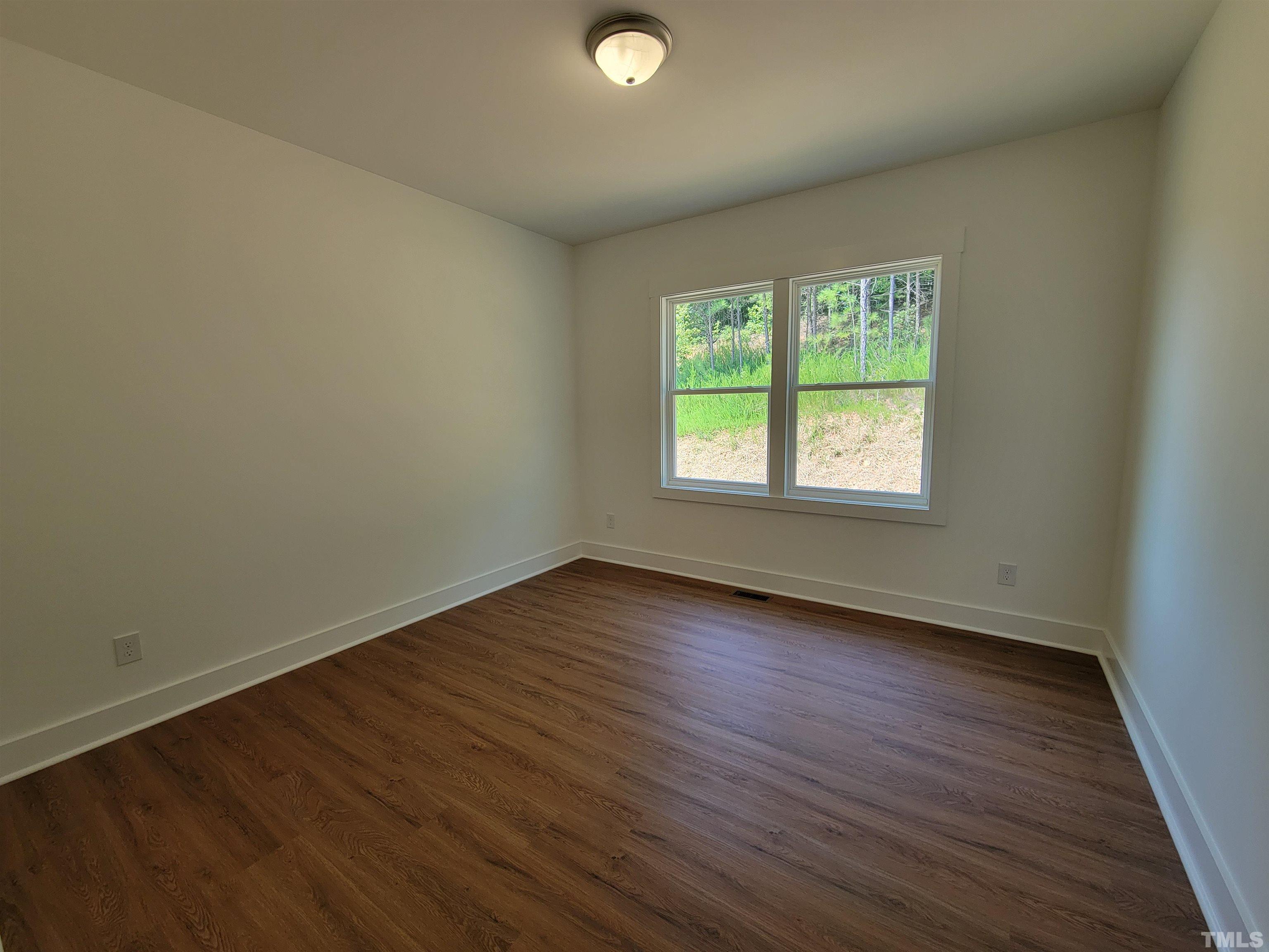 104 Glasgow Street Stem, NC 27581 - Photo 12 of 21 an empty room with wooden floor and windows