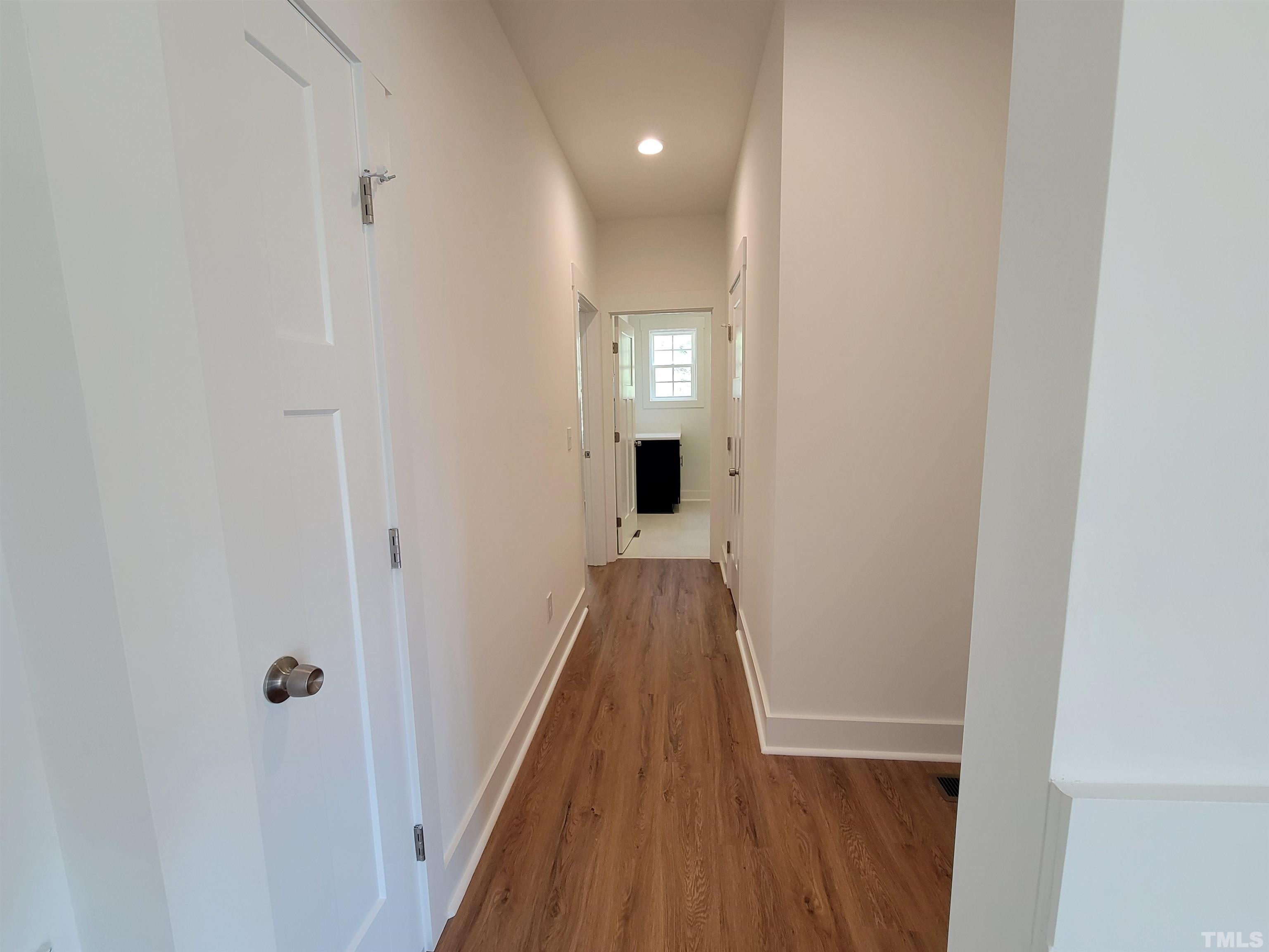 104 Glasgow Street Stem, NC 27581 - Photo 14 of 21 a view of a hallway with wooden floor and a bathroom