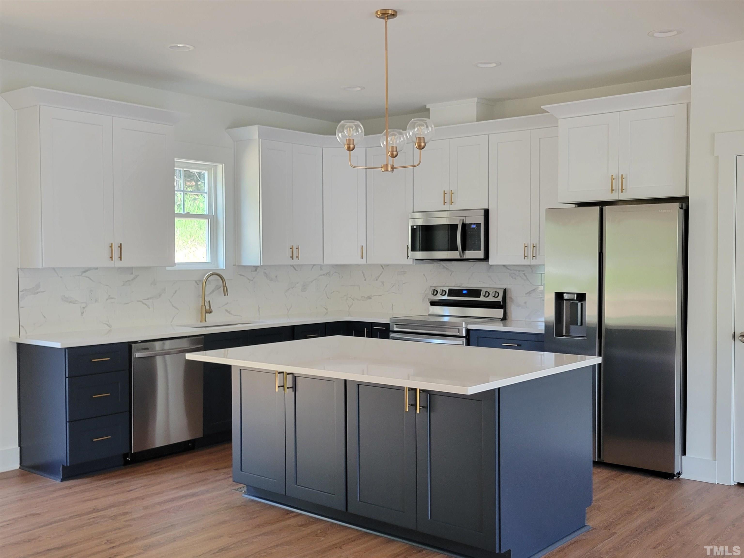 104 Glasgow Street Stem, NC 27581 - Photo 7 of 21 a kitchen with stainless steel appliances granite countertop a sink a stove a refrigerator a microwave oven with white cabinets