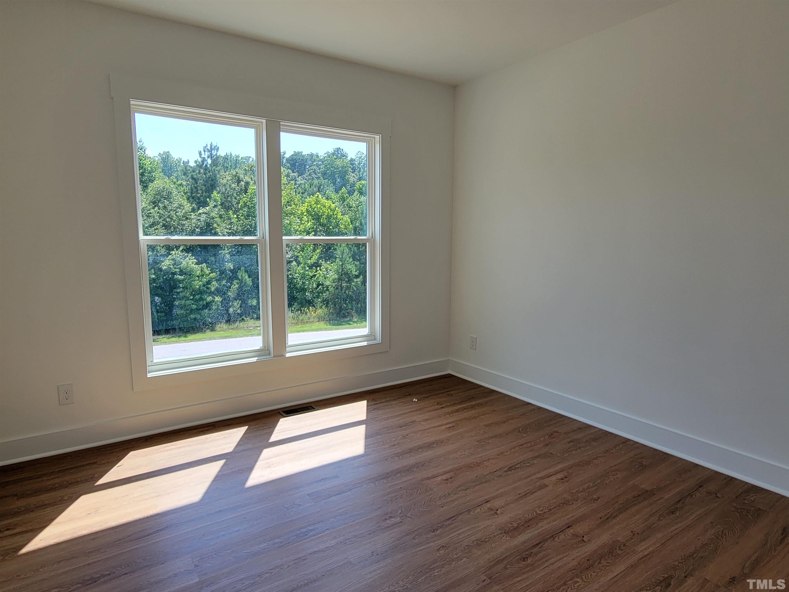104 Glasgow Street Stem, NC 27581 - Photo 10 of 21 a view of an empty room with wooden floor and a window