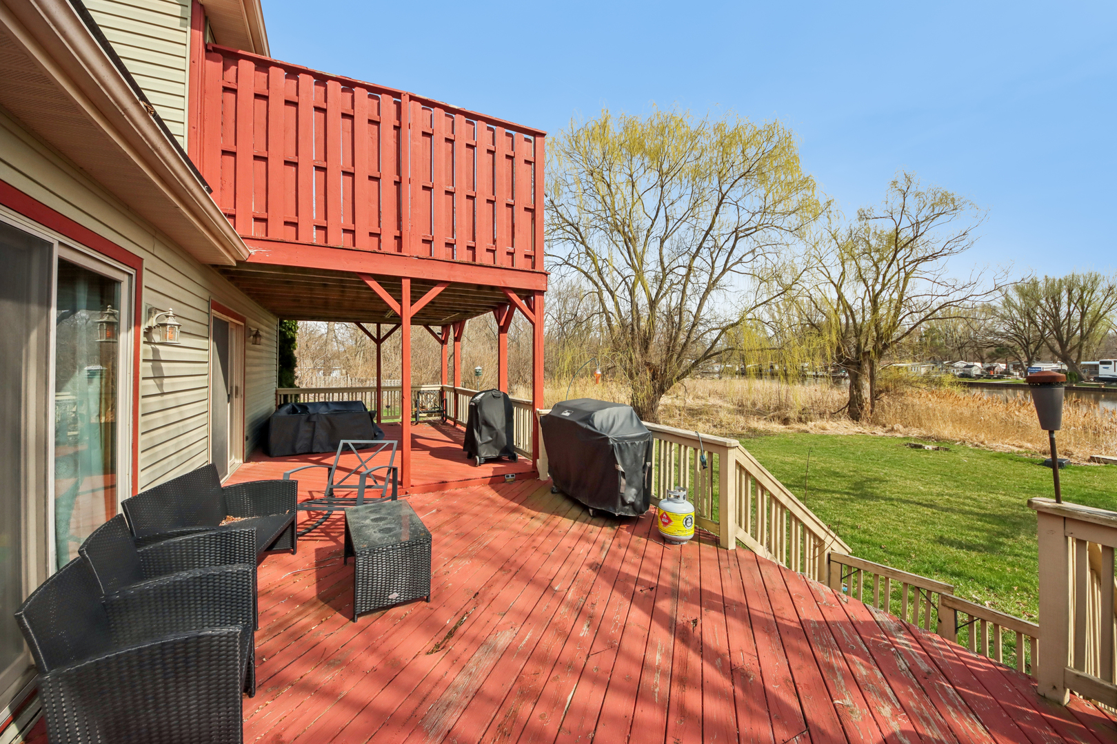 27884 West Riverside Drive Antioch, IL 60002 - Photo 28 of 45 a view of a patio with couches table and chairs and potted plants with wooden floor and fence