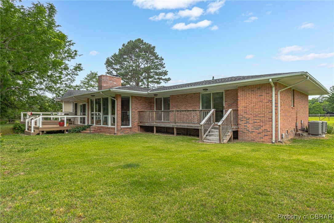 86 Greenfield Road Lancaster, VA 22503 - Photo 6 of 44 Rear view of property featuring a deck, brick siding, a chimney, and a lawn