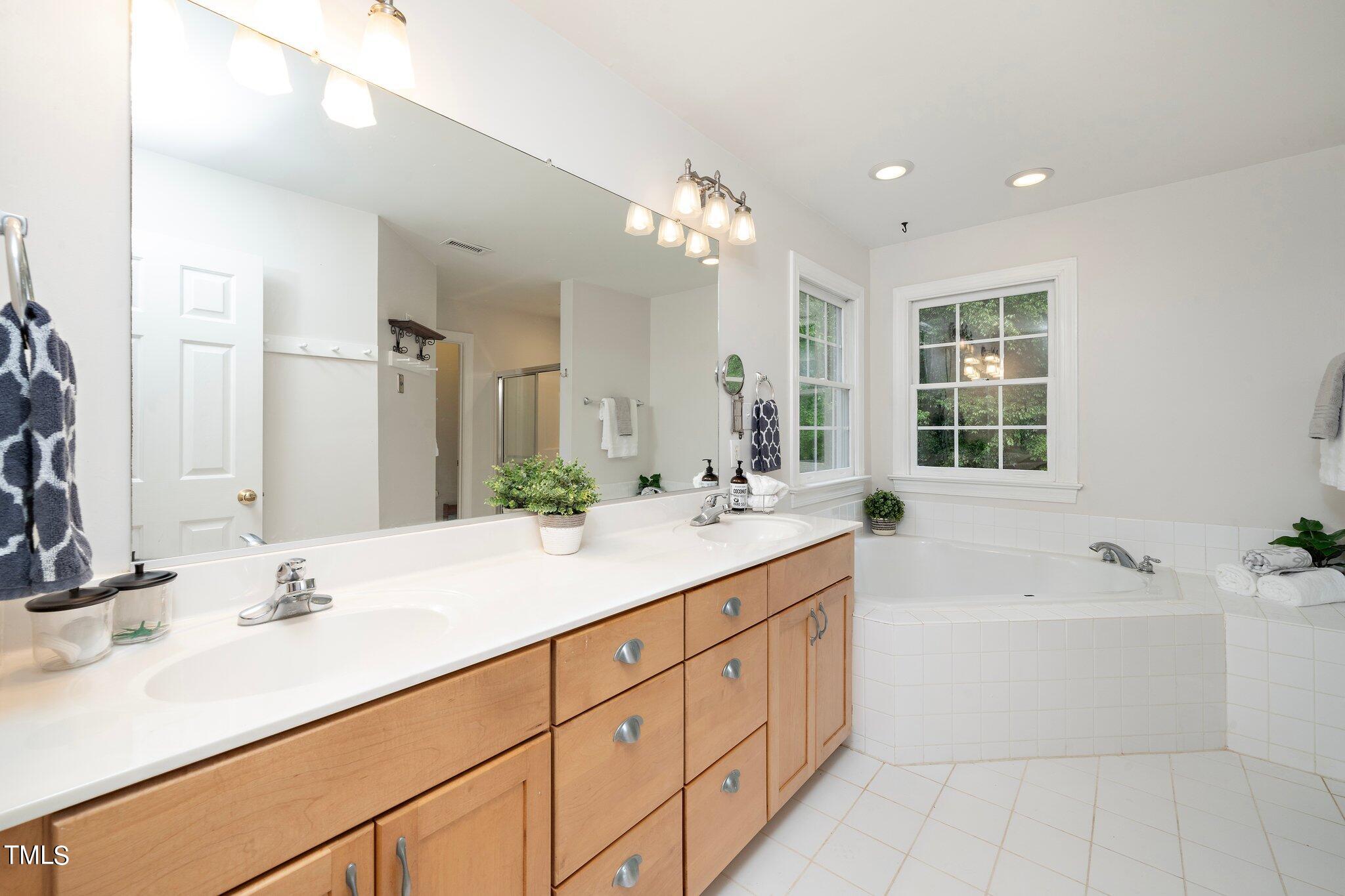4427 Spring Meadows Road Hillsborough, NC 27278 - Photo 19 of 42 a bathroom with a sink double vanity granite tub and a mirror