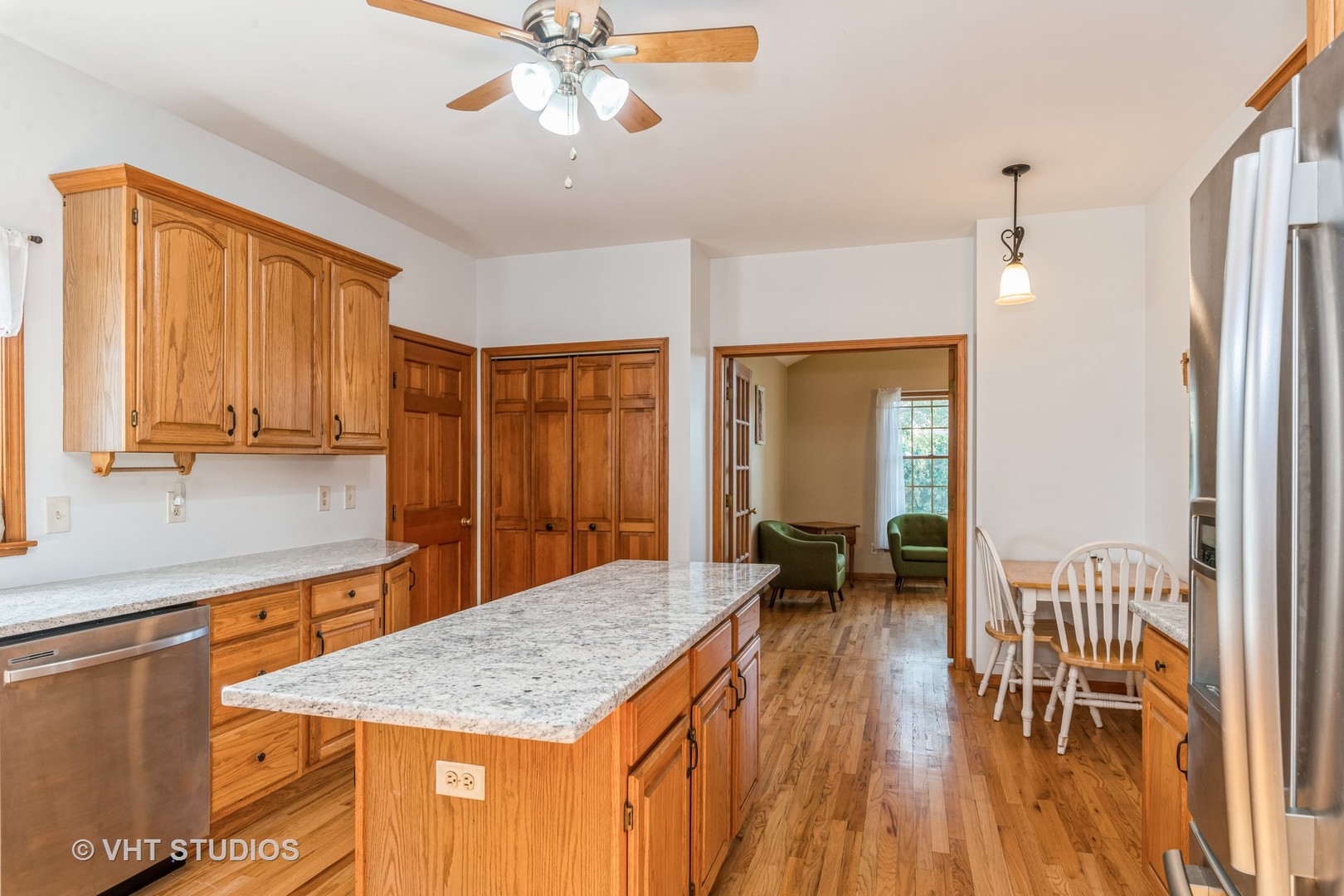 1N200 Denali Road Elburn, IL 60119 - Photo 4 of 23 a dining hall with stainless steel appliances granite countertop a refrigerator a sink a dining table and chairs with wooden floor