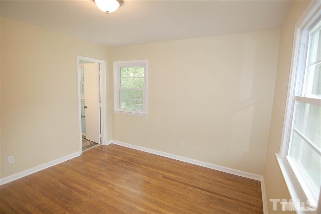 556 Dacian Road Raleigh, NC 27610 - Photo 12 of 20 an empty room with wooden floor and windows