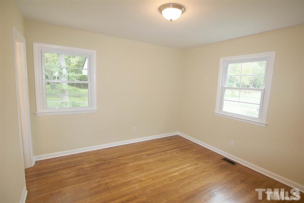 556 Dacian Road Raleigh, NC 27610 - Photo 13 of 20 an empty room with wooden floor and windows