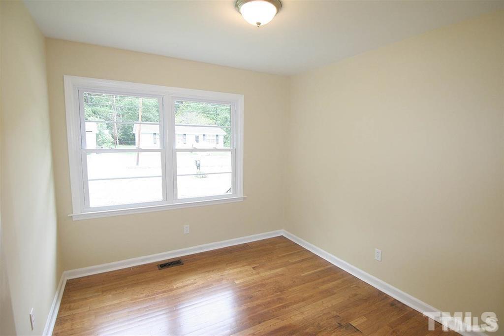 556 Dacian Road Raleigh, NC 27610 - Photo 17 of 20 an empty room with wooden floor and windows