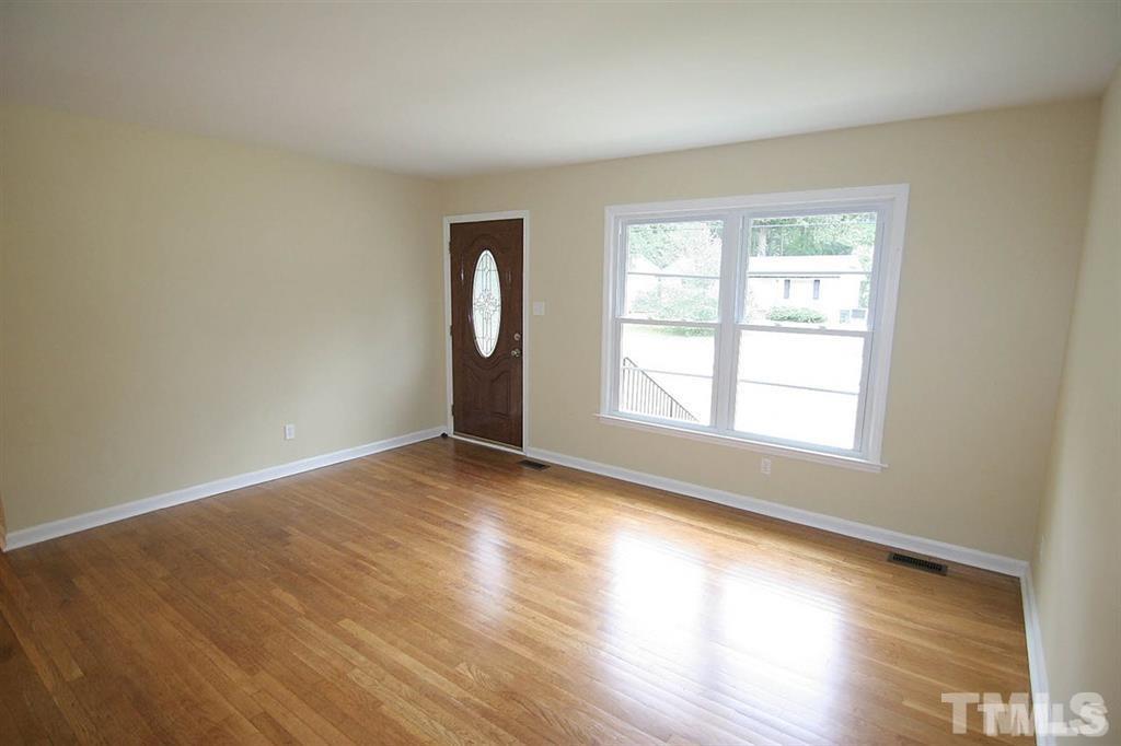 556 Dacian Road Raleigh, NC 27610 - Photo 3 of 20 an empty room with wooden floor and windows