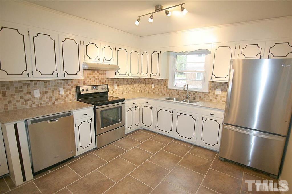 556 Dacian Road Raleigh, NC 27610 - Photo 5 of 20 a kitchen with stainless steel appliances granite countertop a sink a stove a refrigerator cabinets and a window