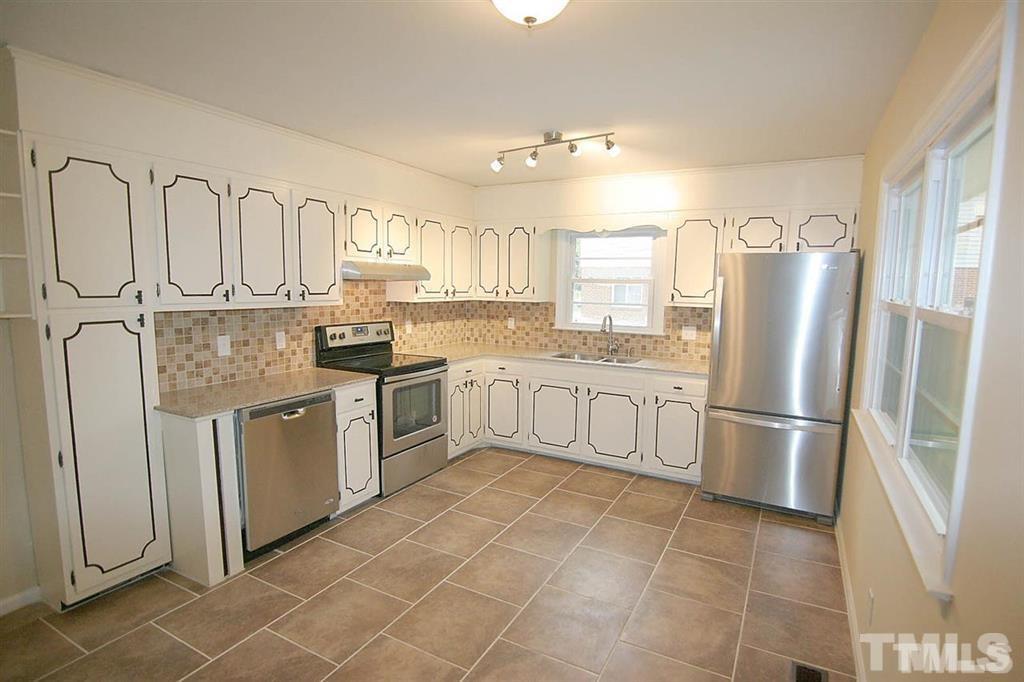 556 Dacian Road Raleigh, NC 27610 - Photo 6 of 20 a kitchen with stainless steel appliances granite countertop a refrigerator sink and cabinets