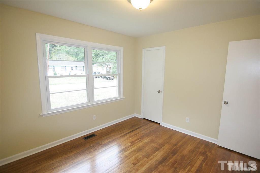 556 Dacian Road Raleigh, NC 27610 - Photo 10 of 20 an empty room with wooden floor and windows