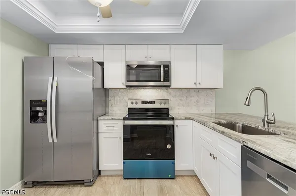 a kitchen with cabinets stainless steel appliances and a sink