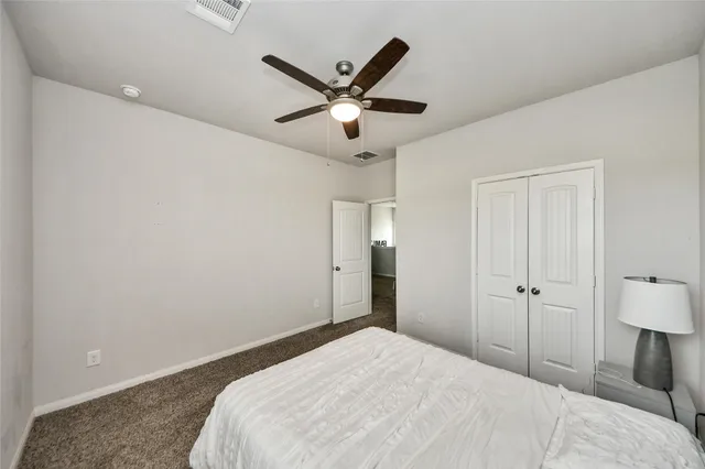 a bedroom with a large bed and a ceiling fan