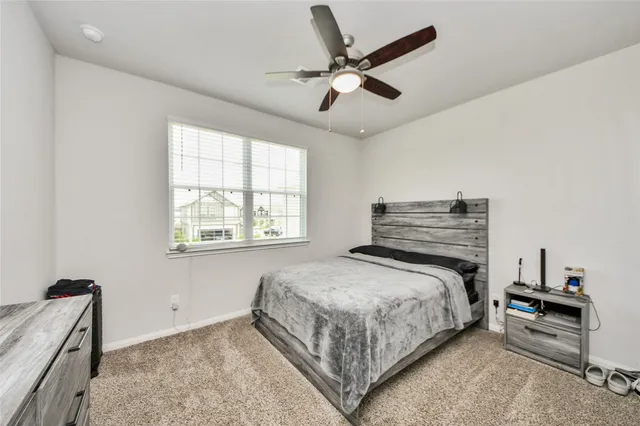 a bedroom with a bed and a ceiling fan