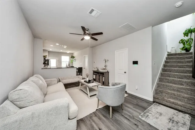 a living room with furniture and a wooden floor