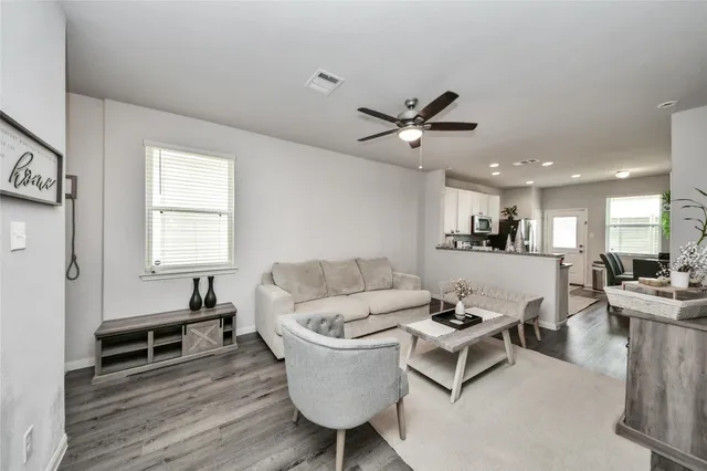 a living room with furniture and a wooden floor