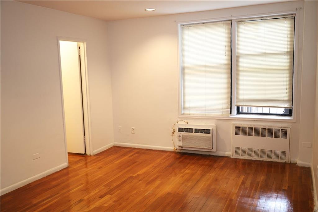 415 Beverley Road, Unit 3J Brooklyn, NY 11218 - Photo 2 of 4 an empty room with wooden floor and windows
