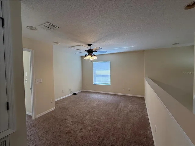 a view of a livingroom with a ceiling fan and window
