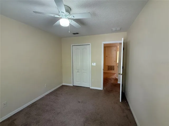en empty room with fan and a ceiling fan