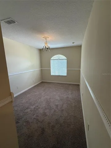 an empty room with windows and fireplace
