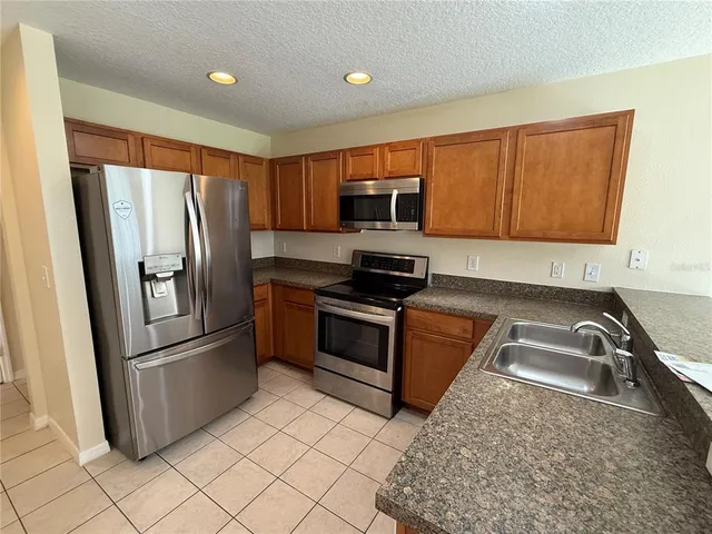 a kitchen with granite countertop a refrigerator and a sink