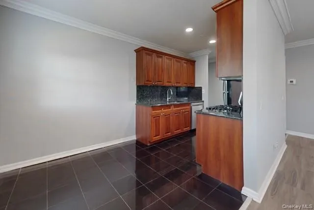 a kitchen with granite countertop a sink a stove and cabinets