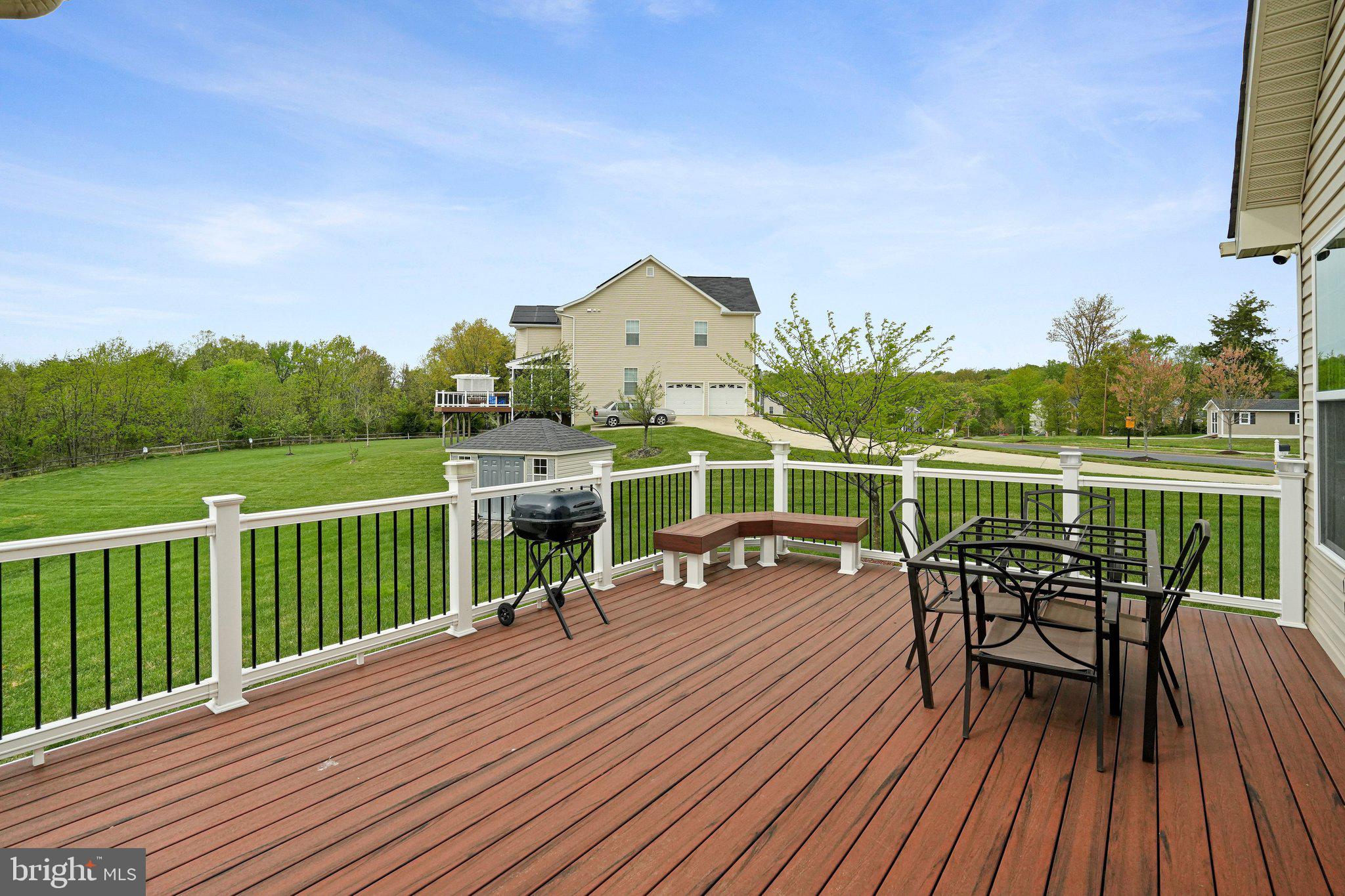 9309 Mount Vernon Way Fort Washington, MD 20744 - Photo 19 of 24 a view of a roof deck with table and chairs a barbeque with wooden floor and fence